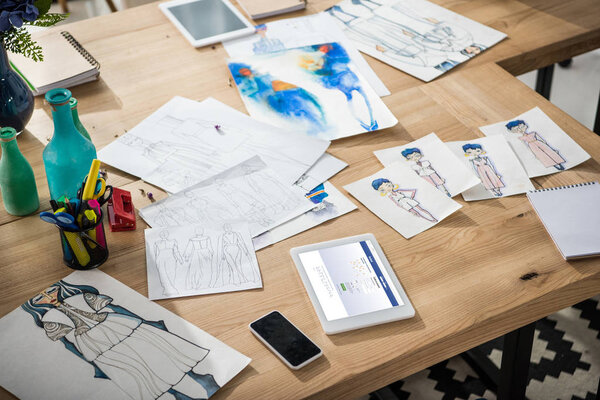 digital devices and sketches on table