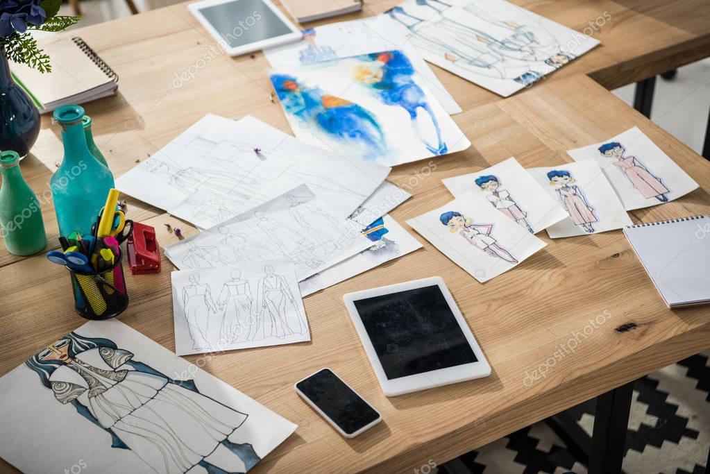 digital devices and sketches on table