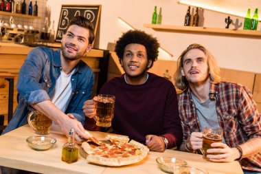 friends with beer watching match in bar  clipart
