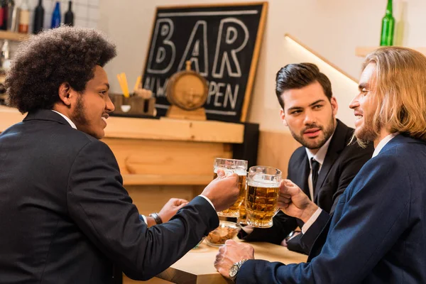 Businessmen drinking beer in bar — Free Stock Photo