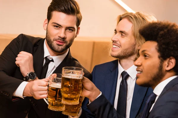 Businessmen drinking beer in bar — Free Stock Photo