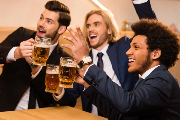 Hombres de negocios con cerveza viendo fútbol en el bar — Foto de stock gratuita