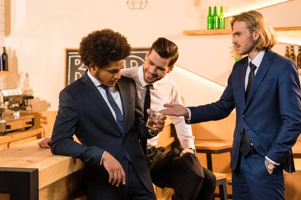 Homens de negócios bebendo uísque no bar — Fotografia de Stock