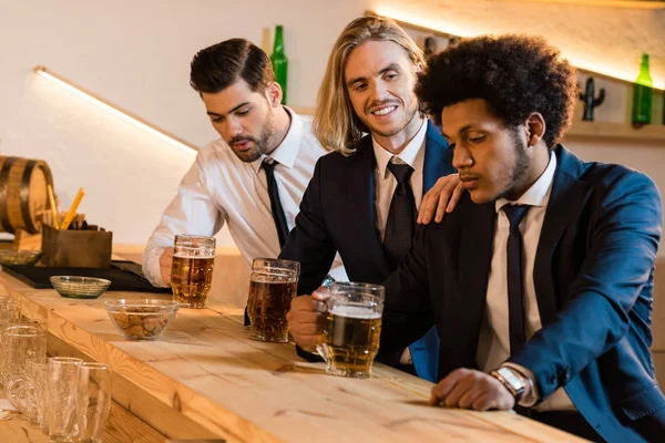 Businessmen drinking beer in bar — Stock Photo, Image