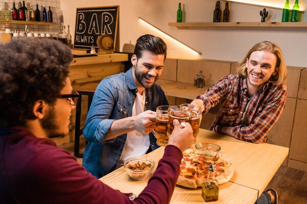 friends with pizza and beer in bar