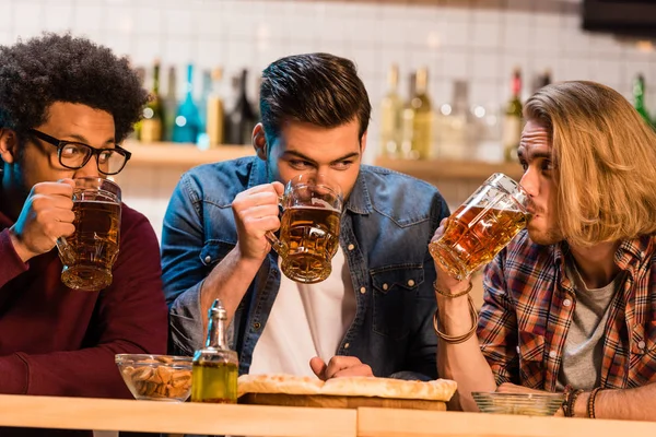 Friends with pizza and beer in bar — Stock Photo, Image
