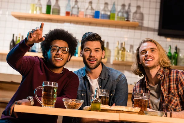 Vänner med pizza och öl i baren — Stockfoto