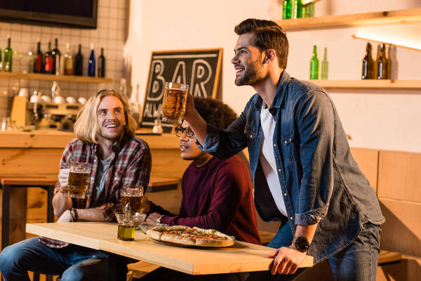 friends with pizza and beer in bar