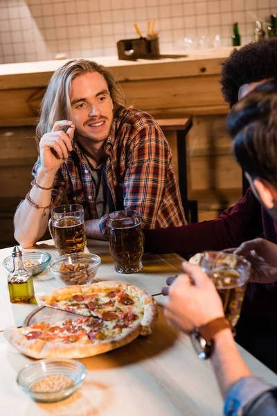 Amigos con pizza y cerveza en el bar — Foto de Stock