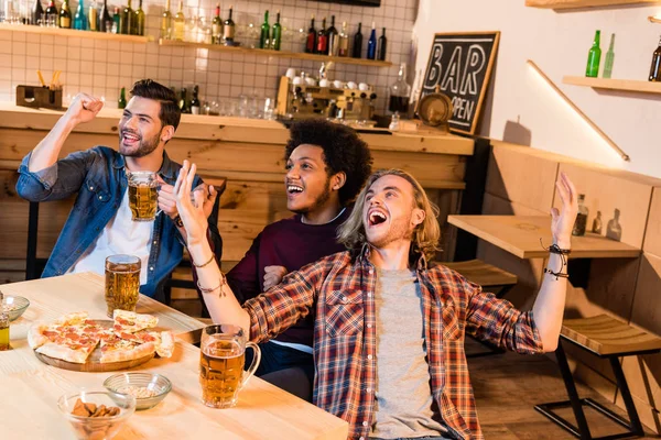 Friends watching soccer game in bar — Stock Photo, Image