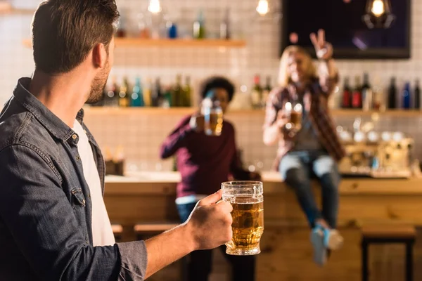 Man with beer looking at friends — Free Stock Photo