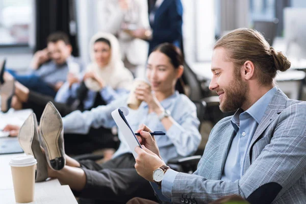 Geschäftsmann macht sich Notizen am Arbeitsplatz — Stockfoto