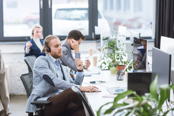 Call center operator in headset at workplace — Stock Photo, Image