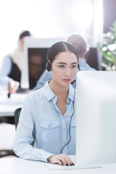 Asiático call center operador en auriculares — Foto de Stock