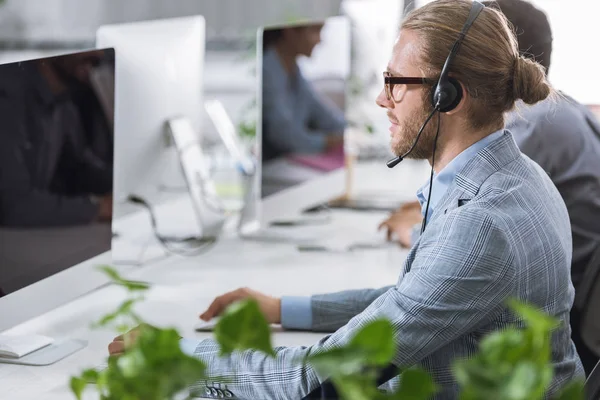 Operador de call center no fone de ouvido no escritório — Fotografia de Stock