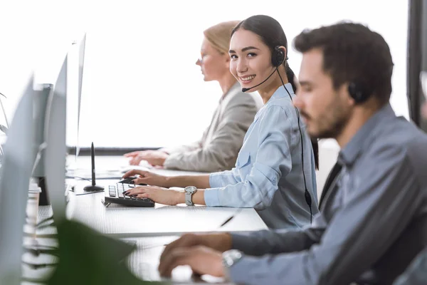 Sorridente asiatico call center operatore — Foto Stock