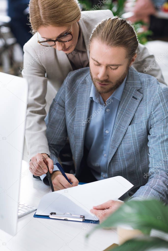 businesswoman checking colleagues work