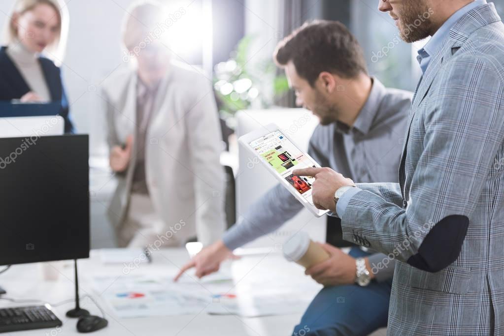 Selective focus of businessman using digital tablet with ebay logo on screen in office