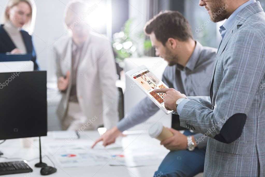 Selective focus of businessman using tablet during work in office