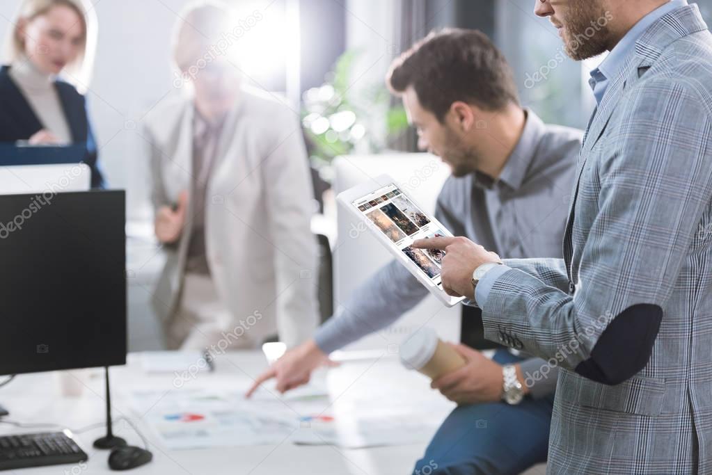 Selective focus of businessman using tablet during work in office