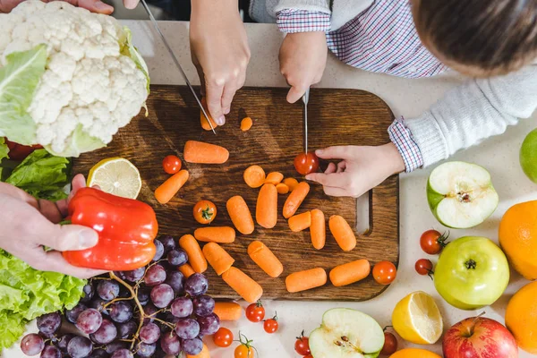 Hands slicing vegetables on chopping board — Stock Photo, Image