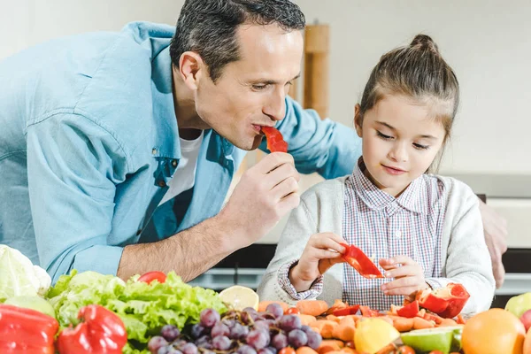 Pai com filha comendo pimenta — Fotografia de Stock