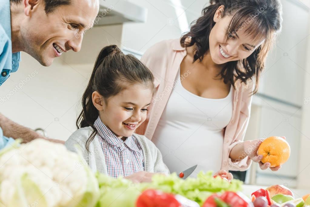 happy smiling family making salad together at kitchen 