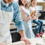Kaukasische en gelukkige familie in meel maken deeg op keuken