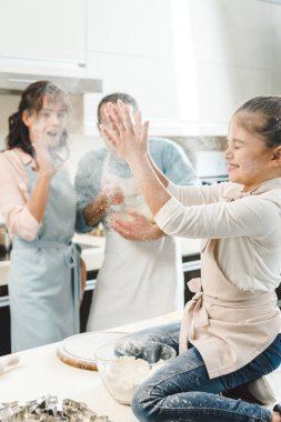 happy family, little kid clapping hands with flour at kitchen clipart