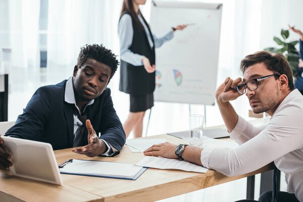 усталые бизнесмены, работающие вместе в офисе
