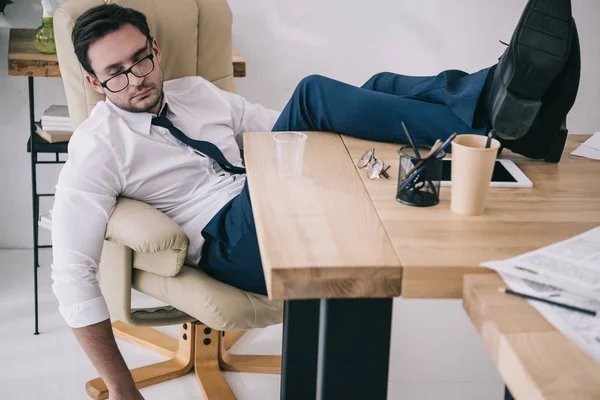 Pengusaha Tidur Kursi Berlengan Dengan Kaki Atas Meja Kantor — Stok Foto