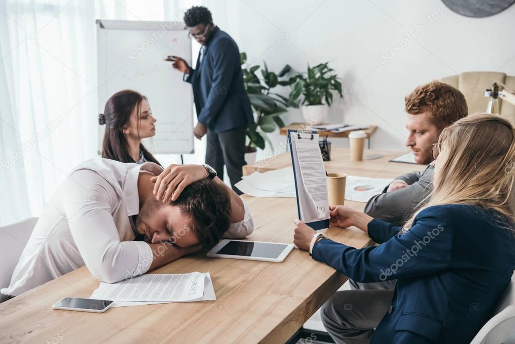 sleepy businesspeople having conversation at office