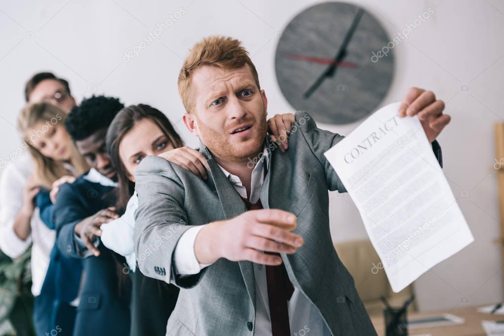 exhausted zombie like businesspeople standing in row and holding contract