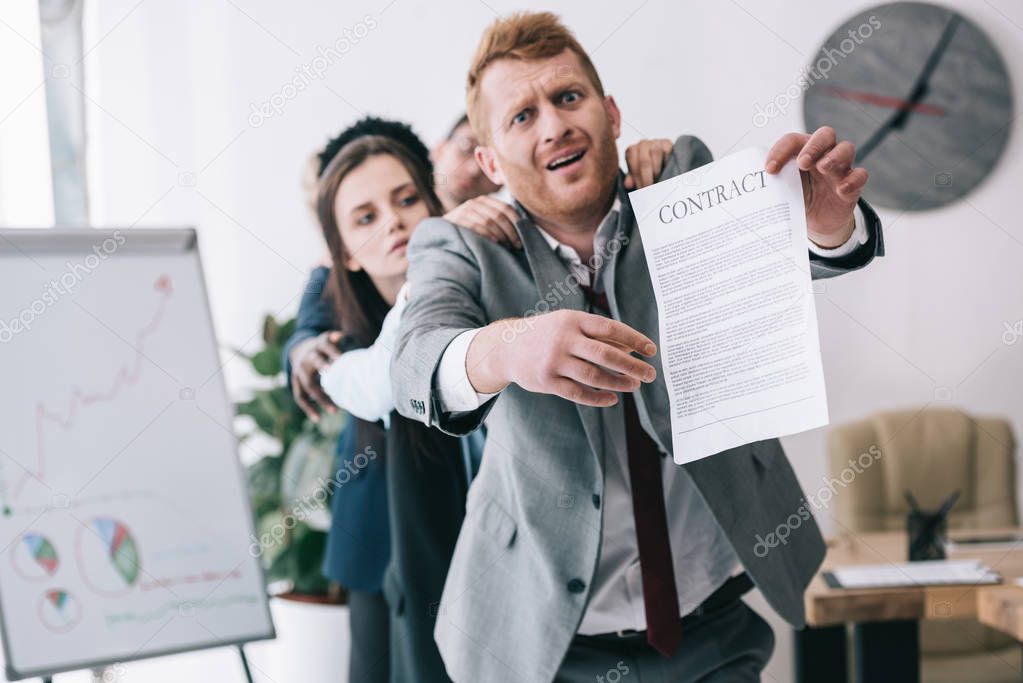 zombie like standing in row and holding contract at office