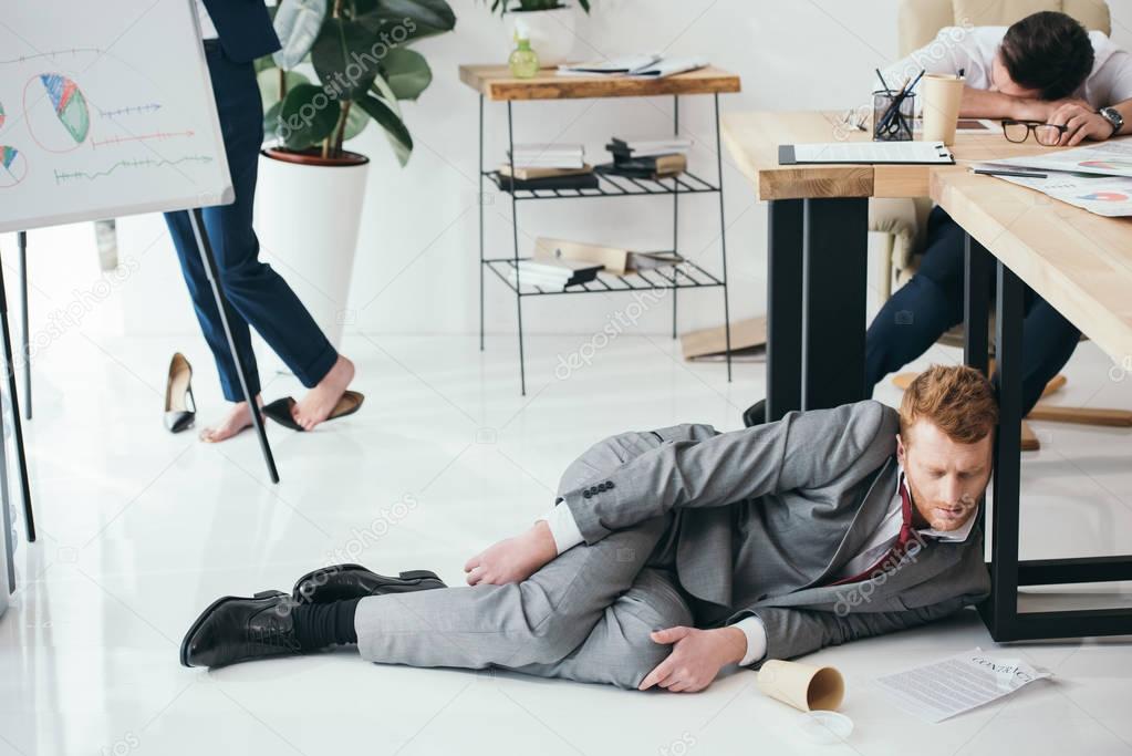 group of exhausted businesspeople sleeping at office