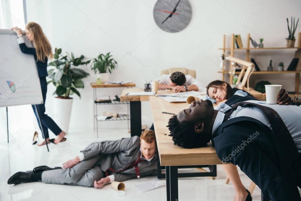 multiethnic group of exhausted businesspeople sleeping at office