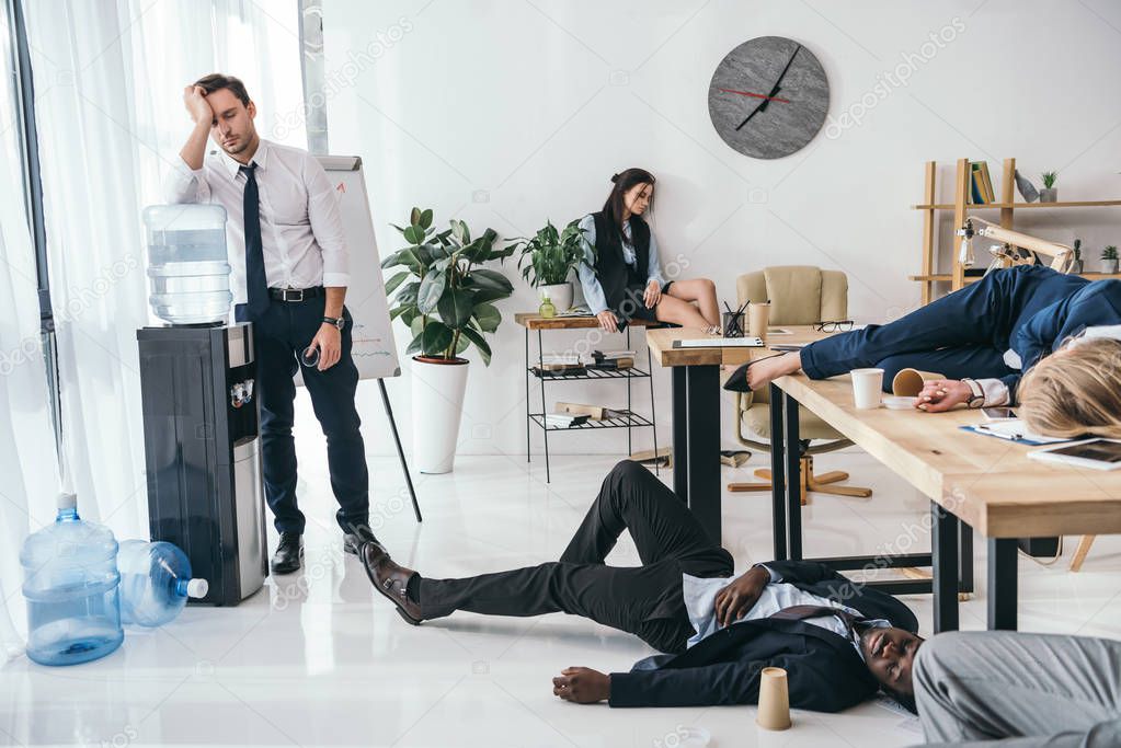 group of exhausted business partners sleeping at office