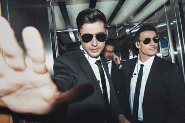 bodyguards stopping paparazzi when celebrity talking by smartphone clipart