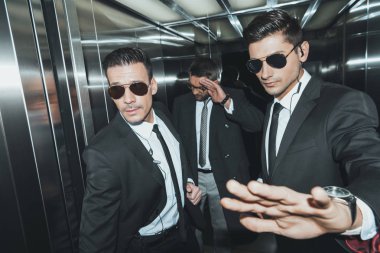 bodyguard stopping paparazzi when celebrity standing in elevator  clipart