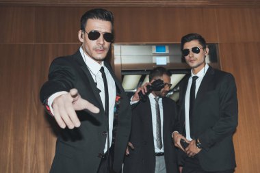 bodyguards stopping paparazzi when celebrity going out from elevator  clipart