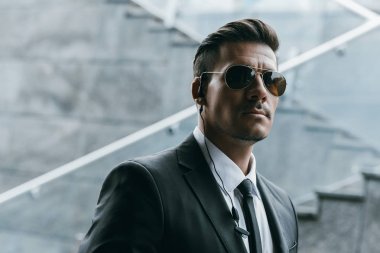 yakışıklı güvenlik görevlisi güvenlik kulaklık ile güneş gözlüğü ayakta