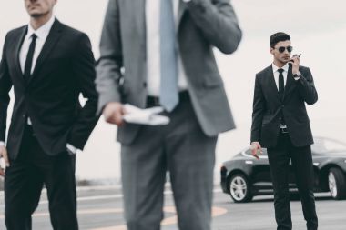 cropped image of bodyguards and businessman walking on helipad  clipart