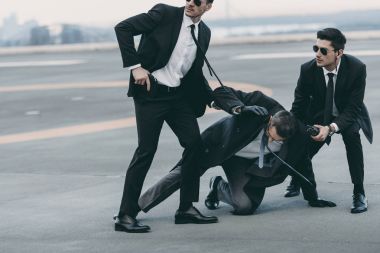 cropped image of two bodyguards protecting falling businessman   clipart