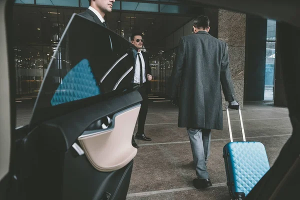 Geschäftsmann Fährt Mit Blauer Tasche Auf Rädern Zum Flughafen — Stockfoto