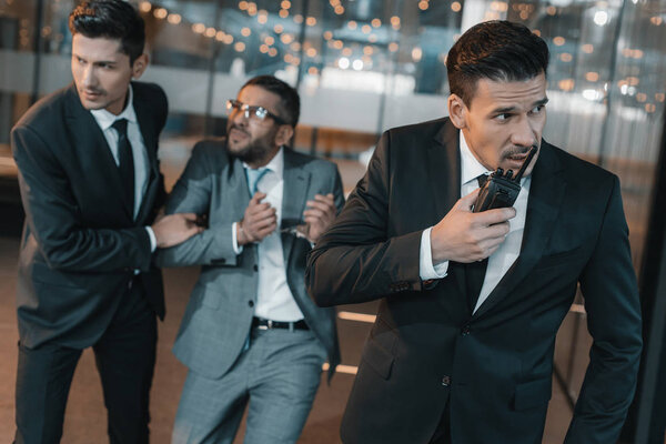 охранник говорит по портативному радио об арестованном преступнике
