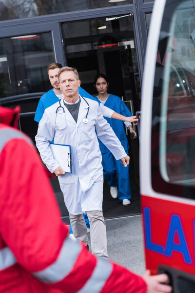 serious doctors going from hospital to ambulance 