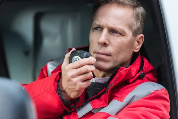 Handsome Middle Aged Male Paramedic Talking Portable Radio While Sitting — Free Stock Photo