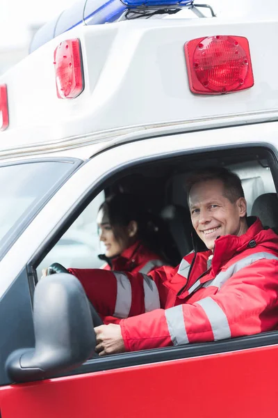 Gelukkig Mannelijke Vrouwelijke Paramedici Zitten Ambulance — Stockfoto