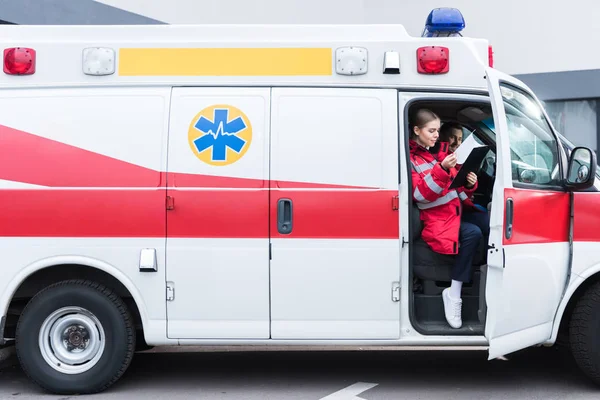 Jovens Paramédicos Masculinos Femininos Sentados Ambulância — Fotografia de Stock