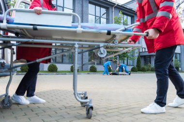 Sağlık görevlileri ambulans sedye için yaralı adam taşıma